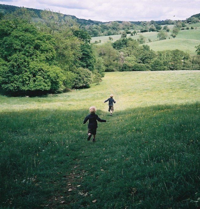 Two Boys Running In A Field